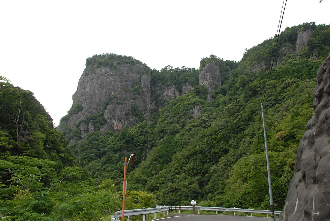 緑の山からそびえる大丹倉の岩壁